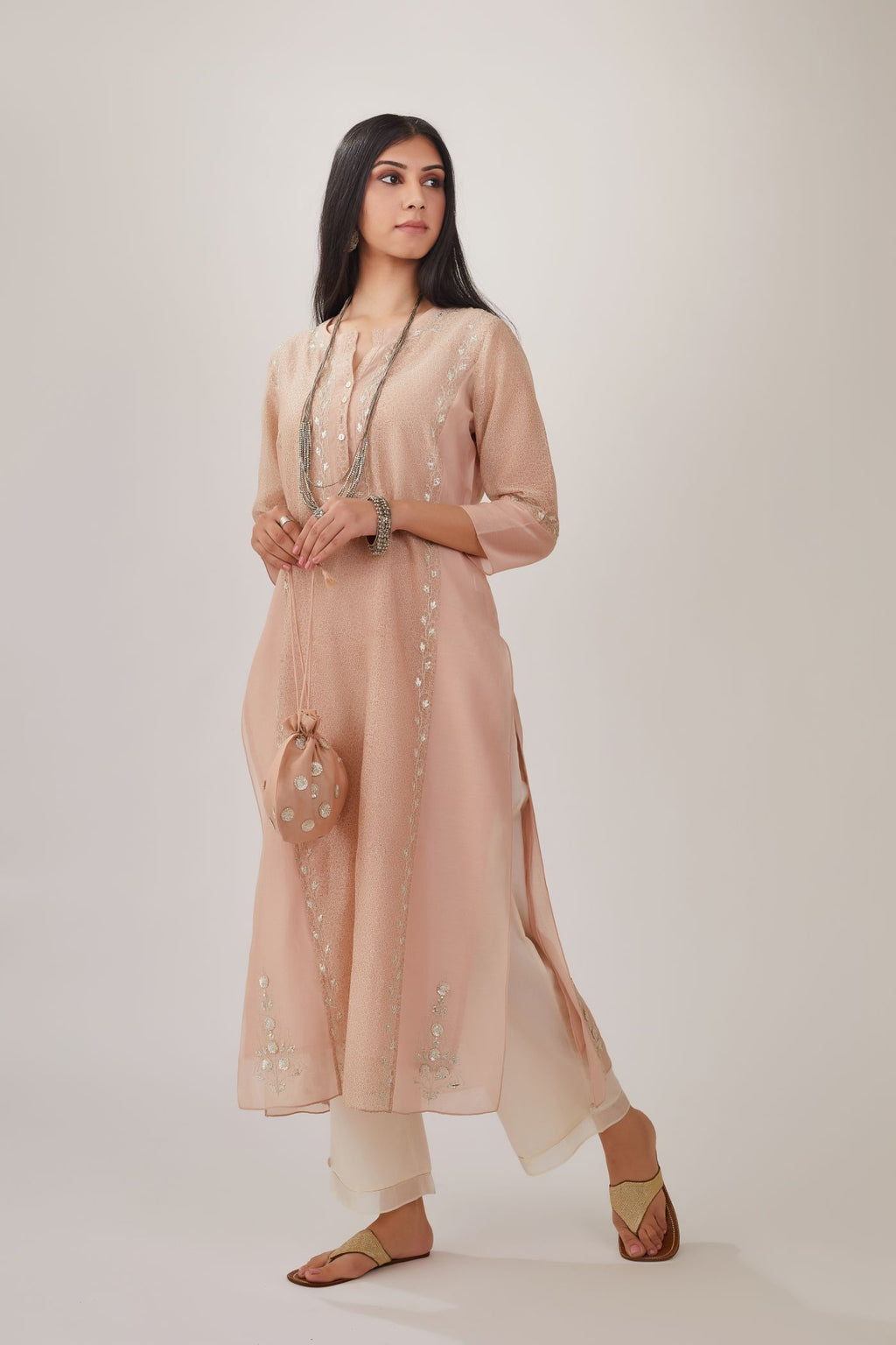 Pink hand block printed silk chanderi kurta with gota embroidery and plain side panels, paired with off white straight pants with gota and silk chanderi fabric detaling at bottom hem