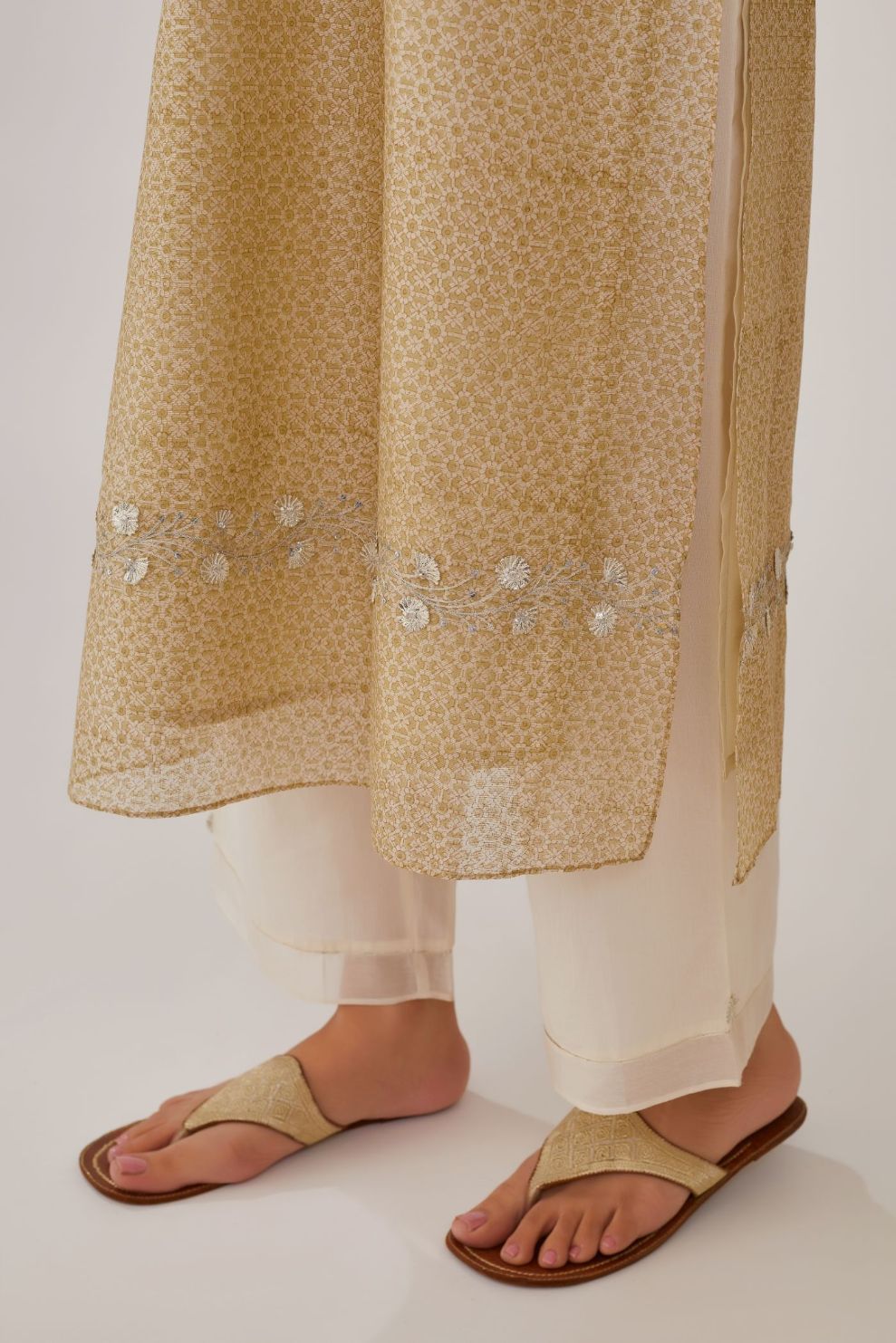 Olive hand block printed silk chanderi straight kurta highlighted with silver gota embroidery, paired with off white straight pants with gota and silk chanderi fabric detaling at bottom hem