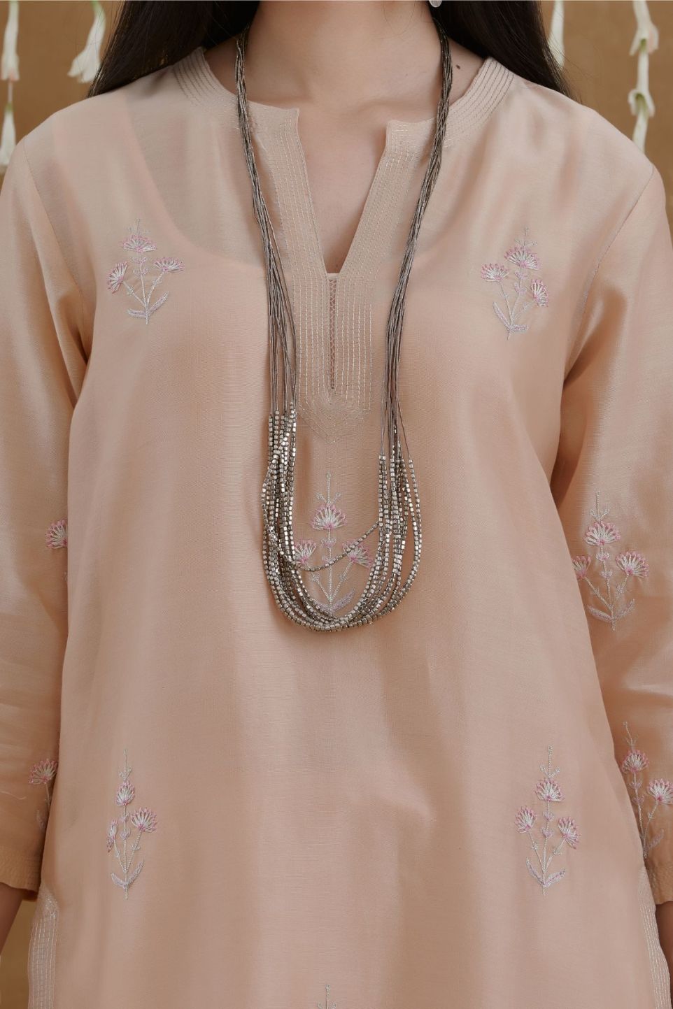 Peach staright kurta set highlighted with all-over silver zari and contrast coloured thread embroidery