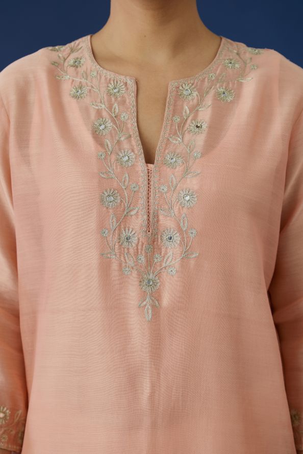 Peach silk chanderi straight kurta set with mirror and zari embroidery at neck and hem.