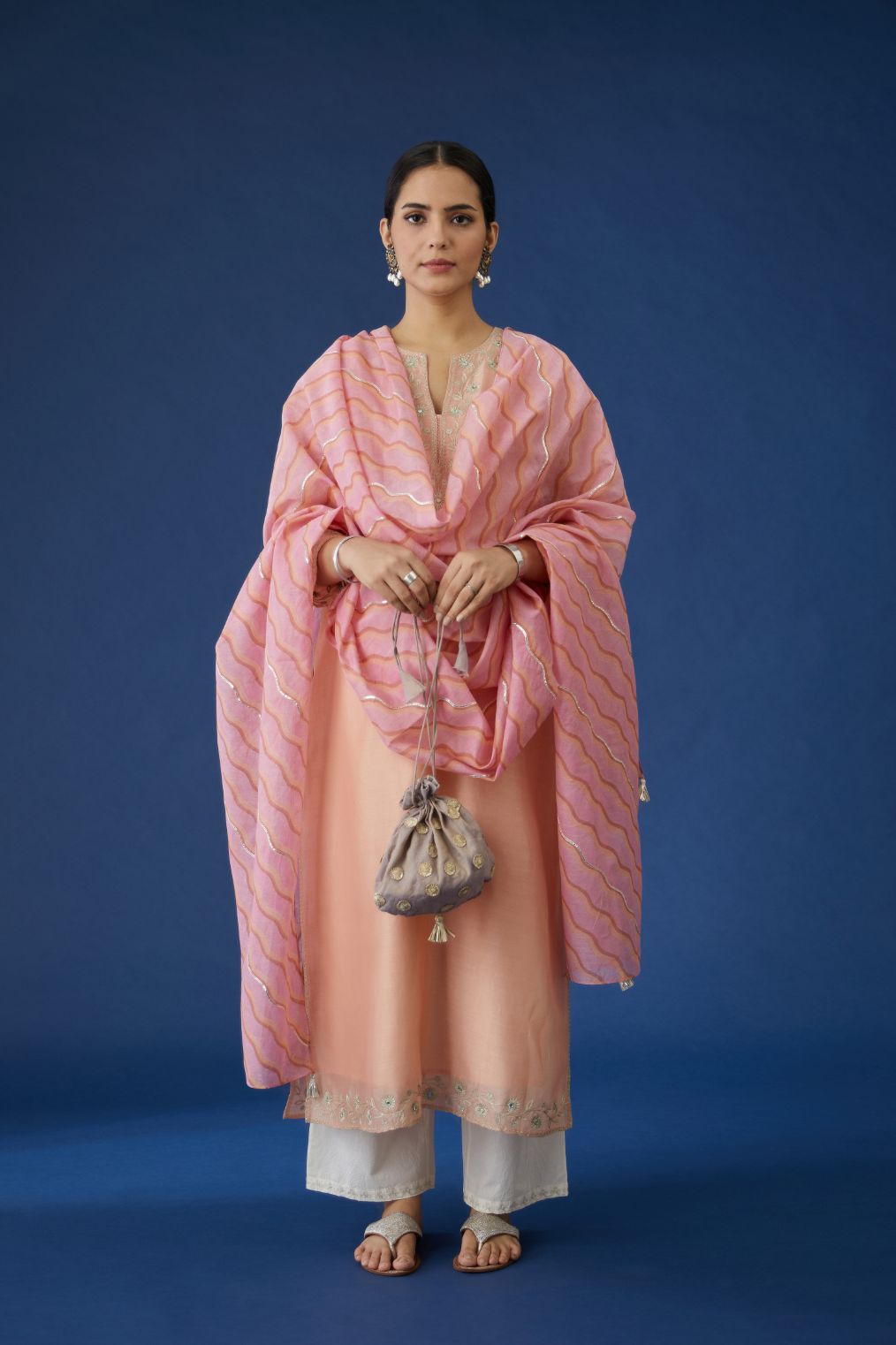 Peach silk chanderi straight kurta set with mirror and zari embroidery at neck and hem.
