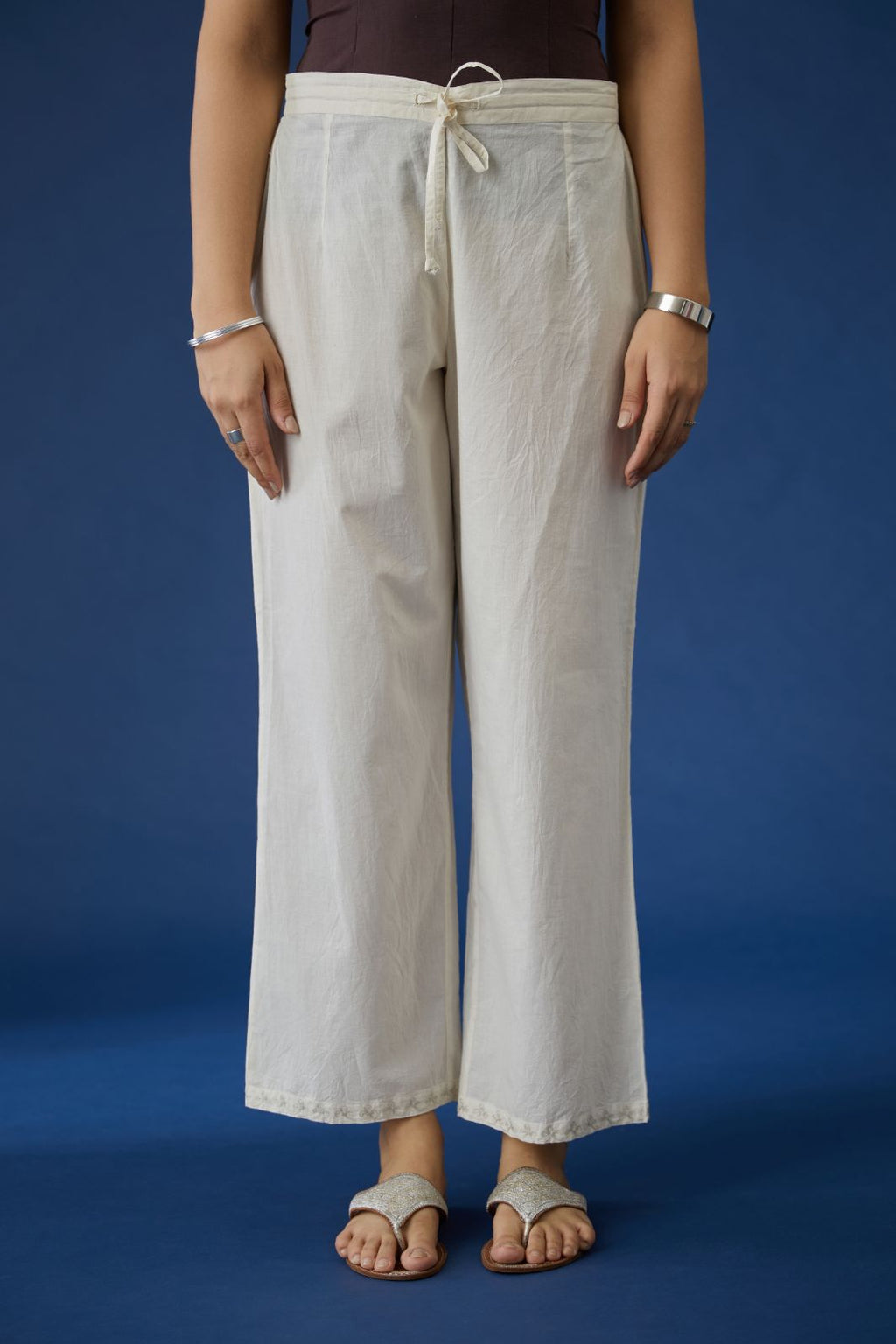 Off white cotton straight pants with silver zari embroidery at bottom hem (Pants)