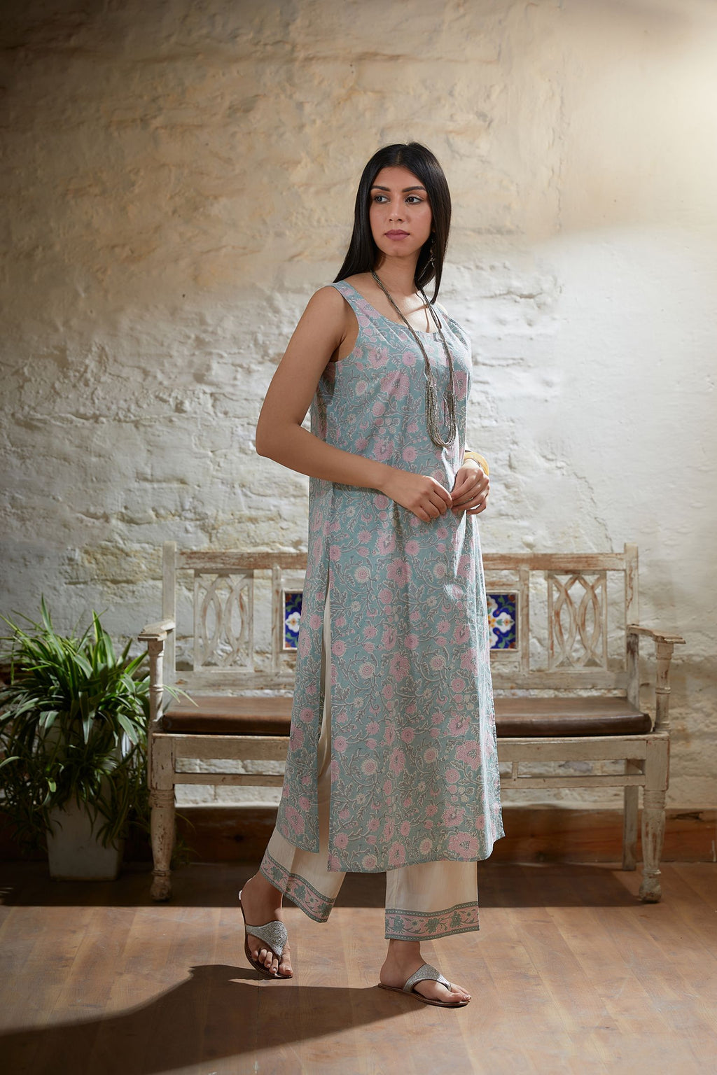 Light teal embroidered kurta with  gathered empire waist line in front and back and printed slip.