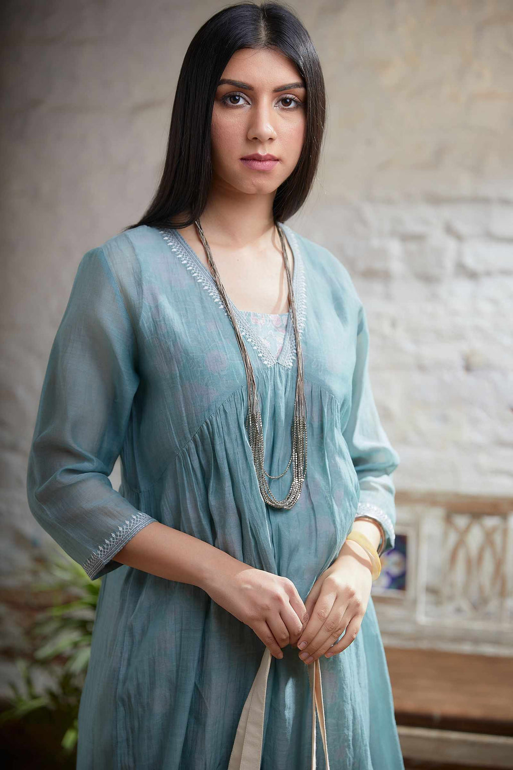 Light teal embroidered kurta with gathered empire waist line in front and back and printed slip, paired with cotton hand block prited pant