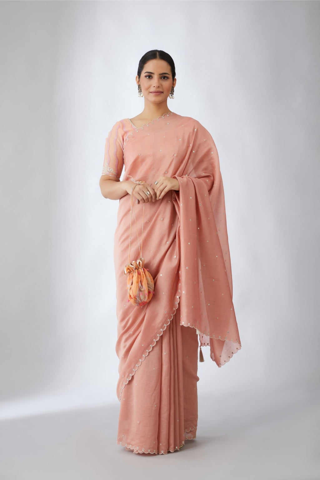 Salmon silk chanderi saree with all-over delicately embroidered silver zari flowers and scalloped edges, accentuated with hand attached mirrors (Saree+Peticot)