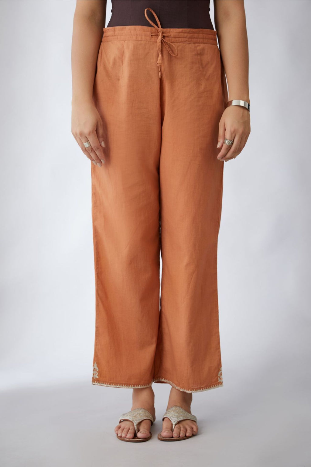 Copper cotton straight pants with silver embroidery detailing at bottom hem (Pants)