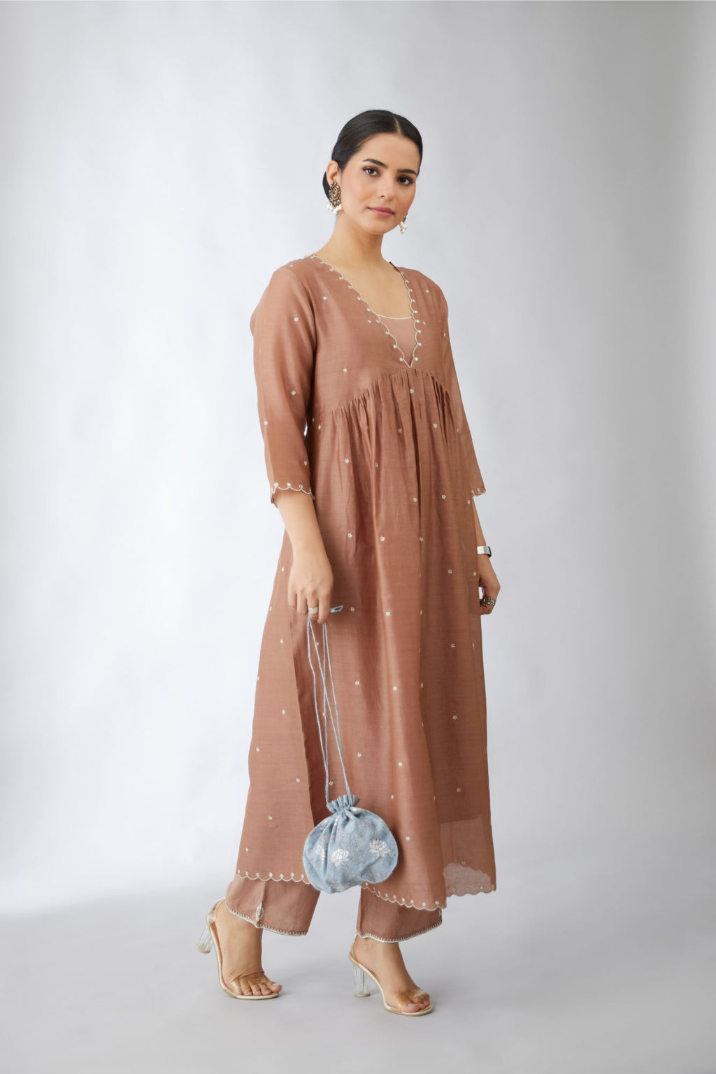 Pecan brown silk chanderi kurta set with delicate silver zari flowers and scalloped edges highlighted with hand attached mirrors.