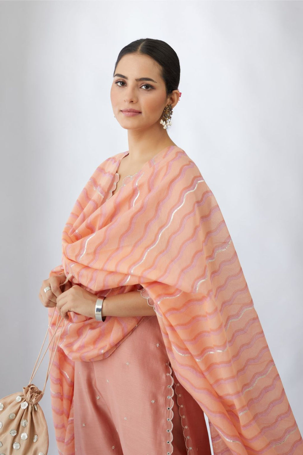 Salmon silk chanderi straight kurta set with delicate all-over silver zari flowers and scalloped edges, highlighted with hand attached mirrors.