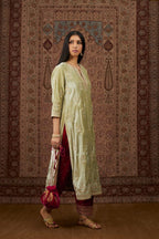 Soft green silk velvet kurta set with gold gota and zari embroidery butas and heavy borders at hem.