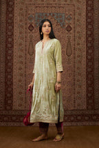 Soft green silk velvet kurta set with gold gota and zari embroidery butas and heavy borders at hem.