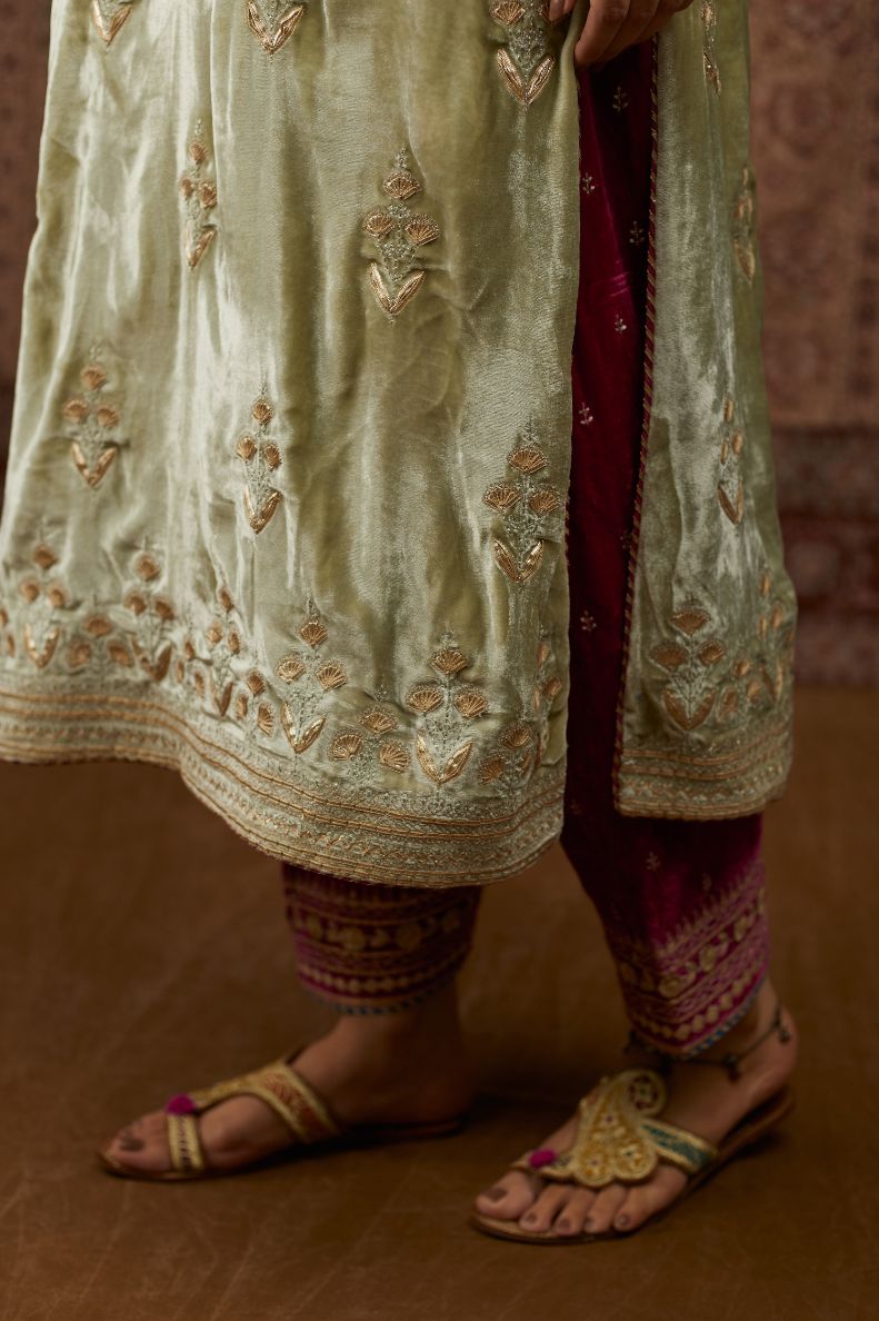 Soft green silk velvet kurta set with gold gota and zari embroidery butas and heavy borders at hem.