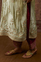 Soft green silk velvet kurta set with gold gota and zari embroidery butas and heavy borders at hem.