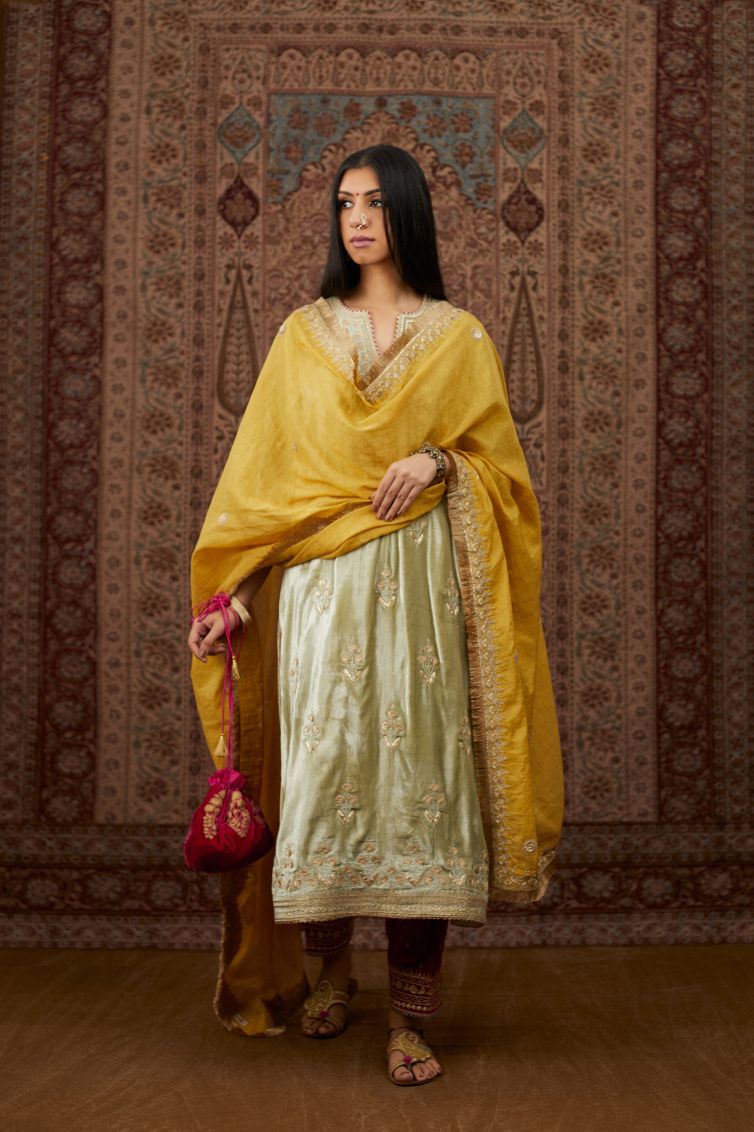 Soft green silk velvet kurta set with gold gota and zari embroidery butas and heavy borders at hem.