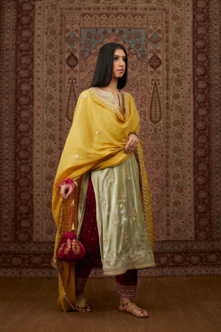 Soft green silk velvet kurta set with gold gota and zari embroidery butas and heavy borders at hem.