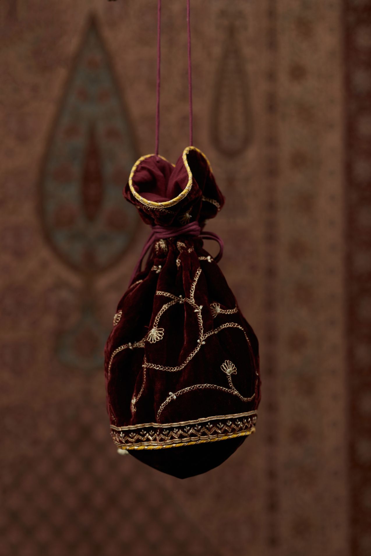 Silk Velvet potli with drawstrings and a shoulder string. It has gold gota and zari embroidery at the bottom and a delicate jaal all over (Potli)