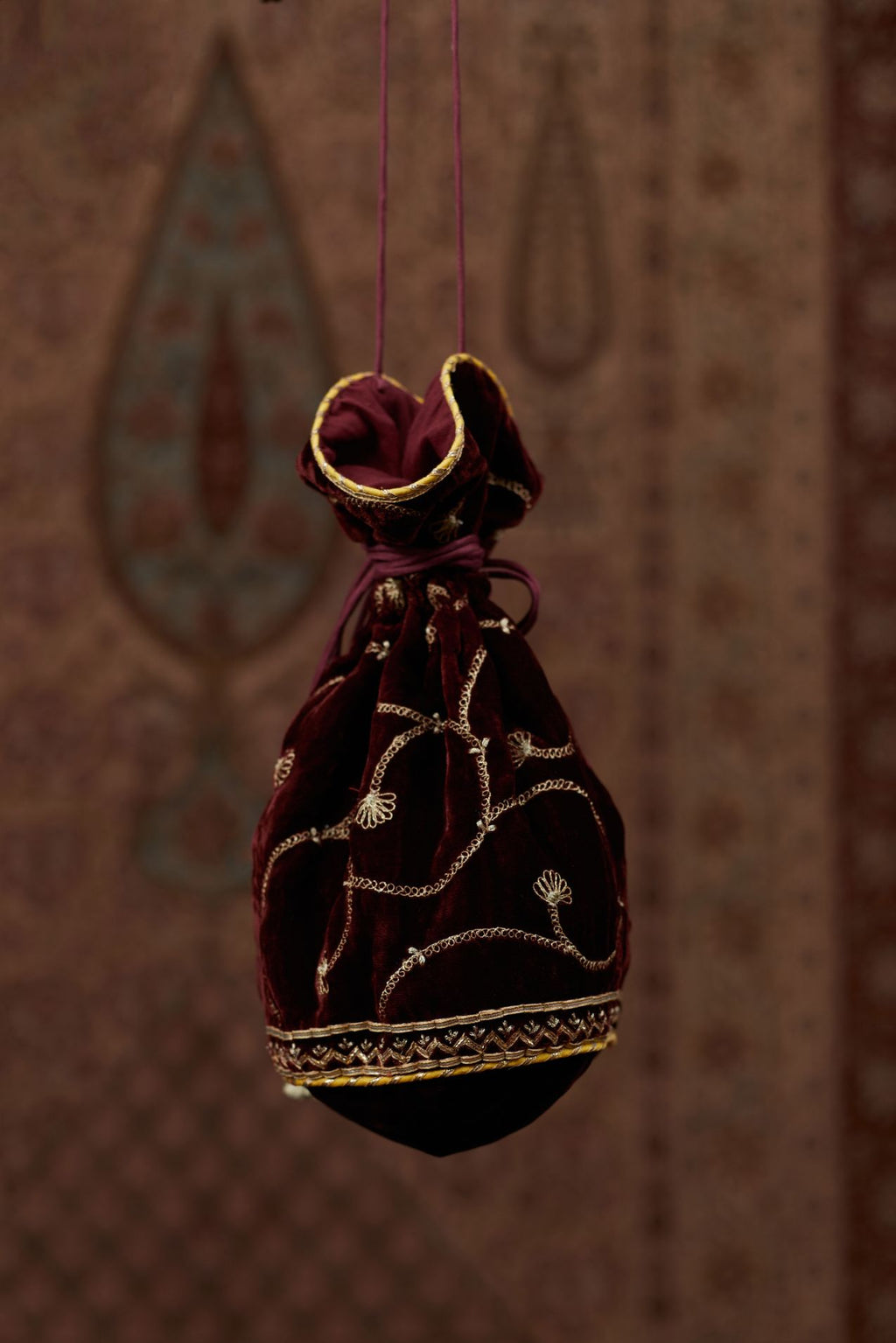 Silk Velvet potli with drawstrings and a shoulder string. It has gold gota and zari embroidery at the bottom and a delicate jaal all over (Potli)