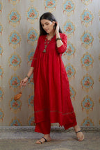 Red hand-crushed silk kurta with wavy empire waistline and gathers, highlighted with beaded tassels and pulled thread embroidery, paired with hand crushed silk pants.