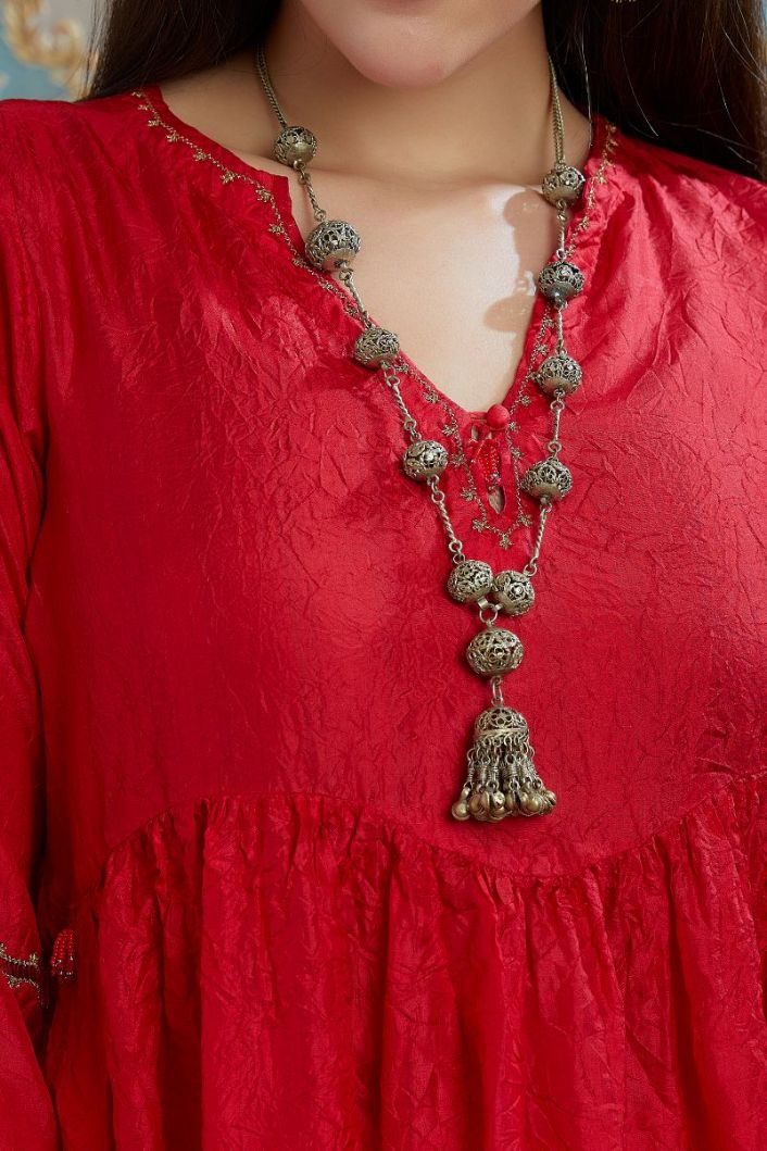 Red hand-crushed silk kurta with wavy empire waistline and gathers, highlighted with beaded tassels and pulled thread embroidery, paired with hand crushed silk pants.