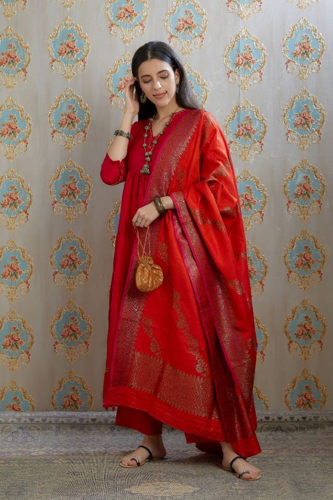 Red hand-crushed silk kurta with wavy empire waistline and gathers, highlighted with beaded tassels and pulled thread embroidery, paired with hand crushed silk pants.