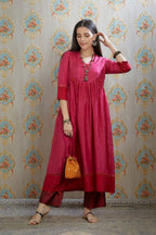Fuchsia hand-crushed silk kurta set with wavy empire waistline and gathers, highlighted with beaded tassels and pulled thread embroidery.