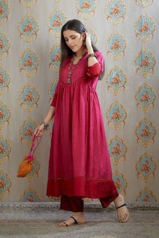 Fuchsia hand-crushed silk kurta set with wavy empire waistline and gathers, highlighted with beaded tassels and pulled thread embroidery.