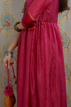 Fuchsia hand-crushed silk kurta set with wavy empire waistline and gathers, highlighted with beaded tassels and pulled thread embroidery.