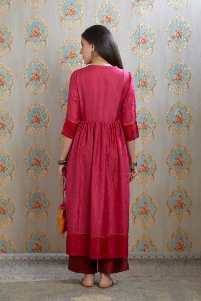Fuchsia hand-crushed silk kurta set with wavy empire waistline and gathers, highlighted with beaded tassels and pulled thread embroidery.