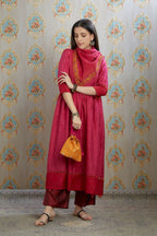 Fuchsia hand-crushed silk kurta set with wavy empire waistline and gathers, highlighted with beaded tassels and pulled thread embroidery.