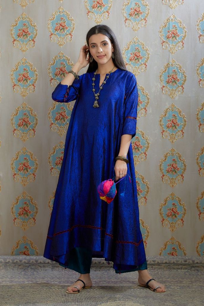 Asymmetric hem blue hand crushed silk kurta with pulled thread embroidery, paired with hand crushed silk pants.