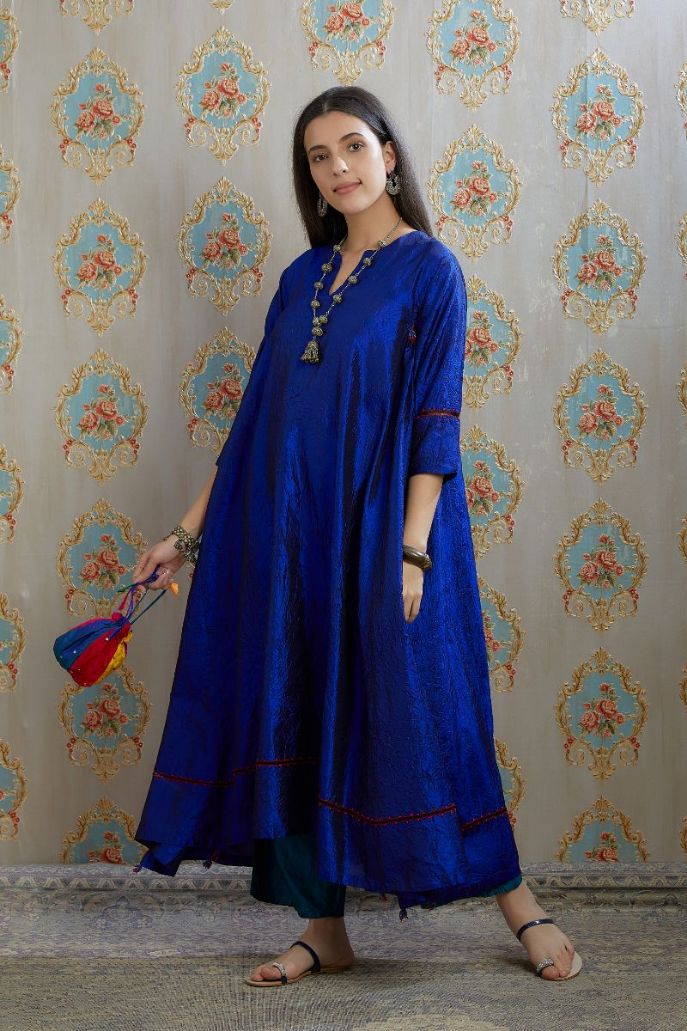 Asymmetric hem blue hand crushed silk kurta with pulled thread embroidery, paired with hand crushed silk pants.