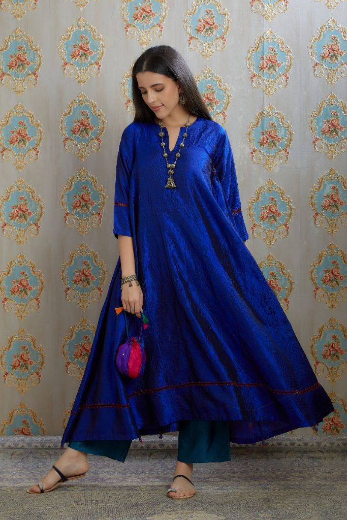 Asymmetric hem blue hand crushed silk kurta with pulled thread embroidery, paired with hand crushed silk pants.