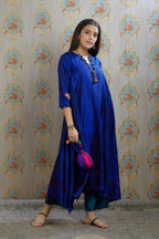 Asymmetric hem blue hand crushed silk kurta with pulled thread embroidery, paired with hand crushed silk pants.