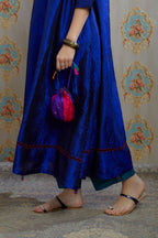Asymmetric hem blue hand crushed silk kurta with pulled thread embroidery, paired with hand crushed silk pants.