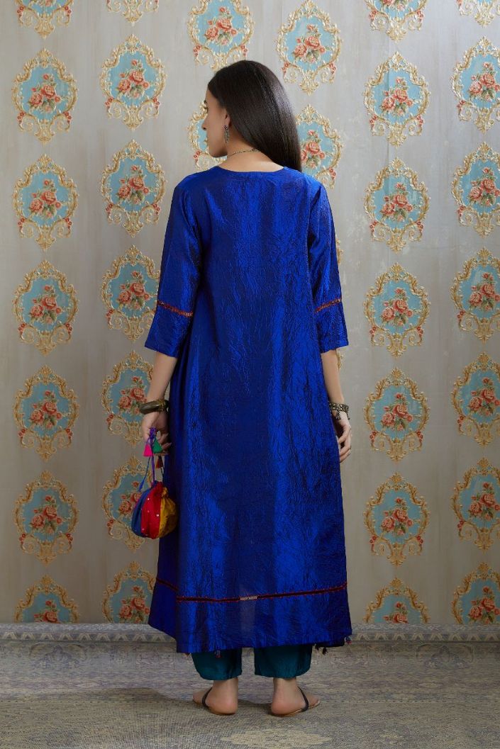 Asymmetric hem blue hand crushed silk kurta with pulled thread embroidery, paired with hand crushed silk pants.