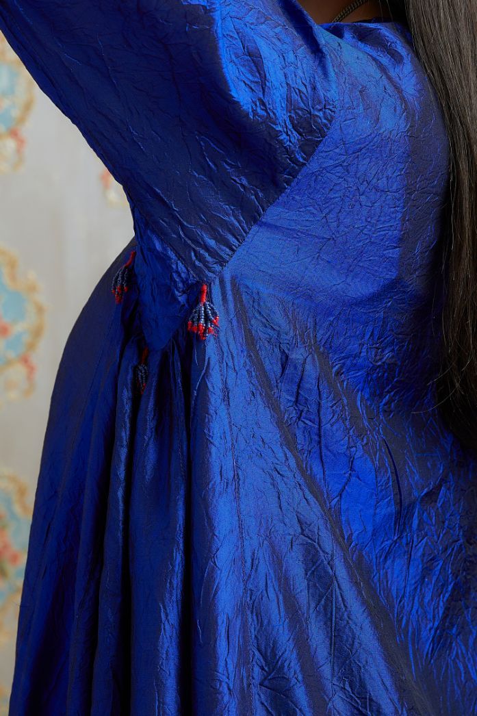 Asymmetric hem blue hand crushed silk kurta with pulled thread embroidery, paired with hand crushed silk pants.