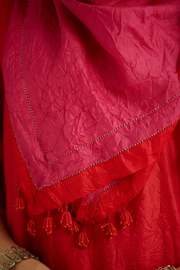 Hand crushed fuchsia silk scarf with contrasting red silk fabric at edges joint with gold zari faggoting