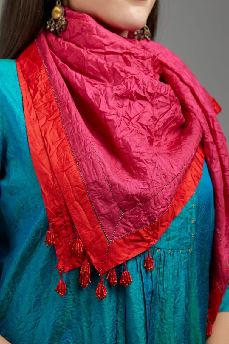 Hand crushed fuchsia silk scarf with contrasting red silk fabric at edges joint with gold zari faggoting